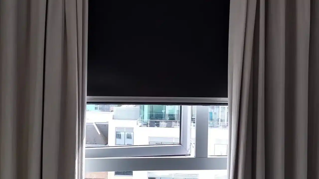 생활암막과 완전암막 커튼 샘플의 빛 투과를 비교하는 모습